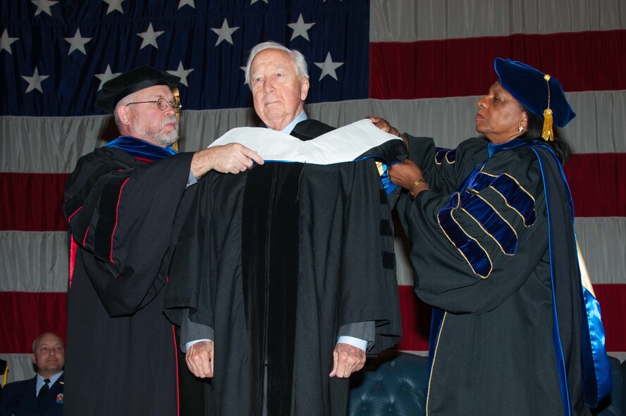 Dr. Matthew Stafford, Air University Academic Affairs president, left, and Dr. Muriel Howard, Air University Board of Visitors president place the Air University academic hood on David McCullough as he receives the Doctorate of Humane Letter degree from Air University during a ceremony Nov. 16, 2015, At Maxwell Air Force Base, Alabama. McCullough was bestowed the honorary degree for his work as an author, historian and narrator. McCullough has received 52 other honorary degrees in the past, but this is his first degree awarded to him by a military university. (U.S. Air Force photo by Melanie Rodgers Cox)