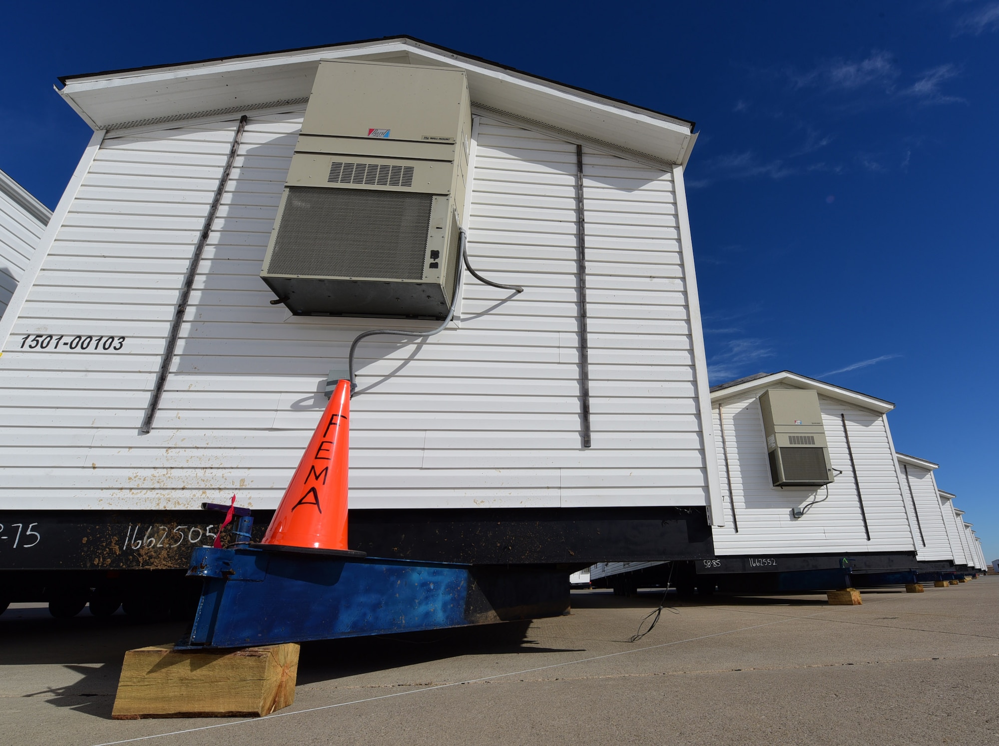 Federal Emergency Management Agency manufactured homes from Selma, Ala., are staged on the alert pad at Ellsworth Air Force Base, S.D., Nov. 5, 2015. FEMA has so far sent 50 fully furnished homes to support Pine Ridge Indian Reservation residents affected by severe storms and flooding. (U.S. Air Force photo by Airman 1st Class James L. Miller/Released)