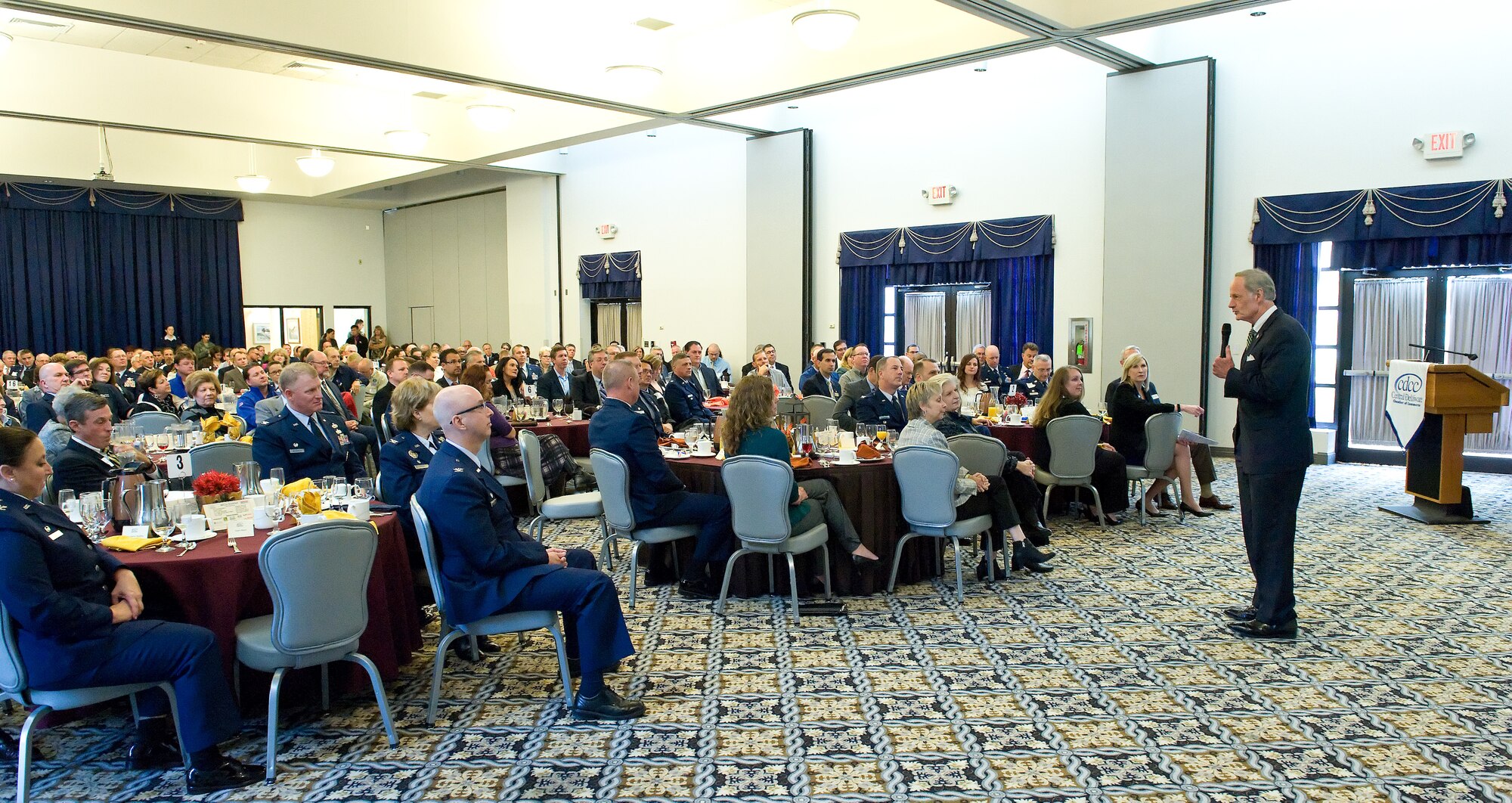 Sen. Tom Carper, D-Del., right, speaks to more than 250 civilian and military attendees during the 2015 Military Construction breakfast and briefing hosted by the Central Delaware Chamber of Commerce Nov. 9, 2015, at The Landings on Dover Air Force Base, Del. Carper talked about the importance of Dover AFB and the possibility of receiving early funding for the proposed C-5M maintenance hangar originally slated for fiscal year 2018 funding. (U.S. Air Force photo/Roland Balik)