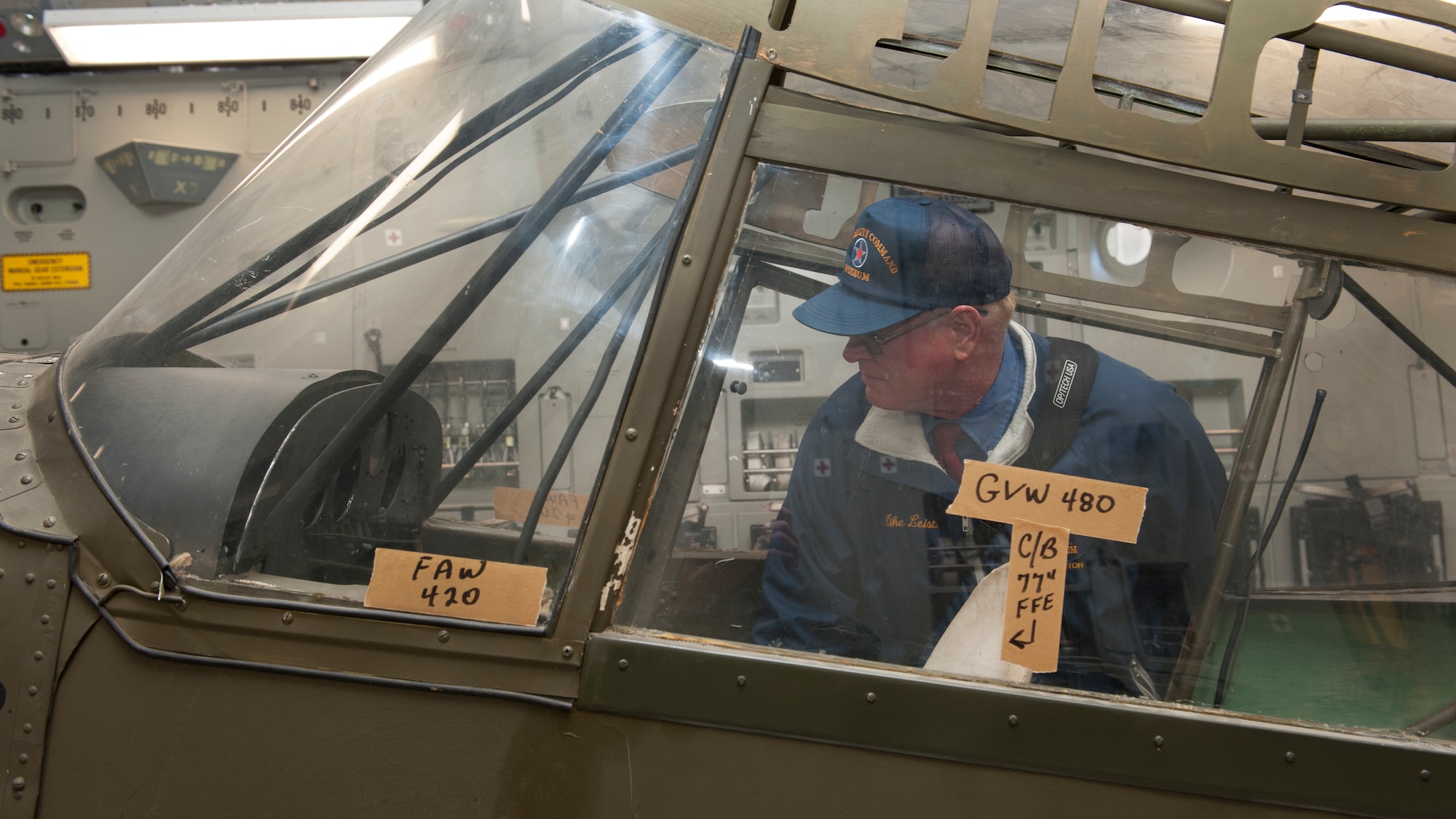 Mike Leister, Air Mobility Command Museum director, examines the inside of the cockpit of a Taylorcraft L-2M “Grasshopper” Nov. 13, 2015, at Wright-Patterson Air Force Base, Ohio. Once the restoration work is complete and proper suspension mounts are fabricated, the L-2M will be hung from the AMC Museum’s hangar ceiling for permanent public display. (U.S. Air Force photo/Senior Airman Zachary Cacicia)