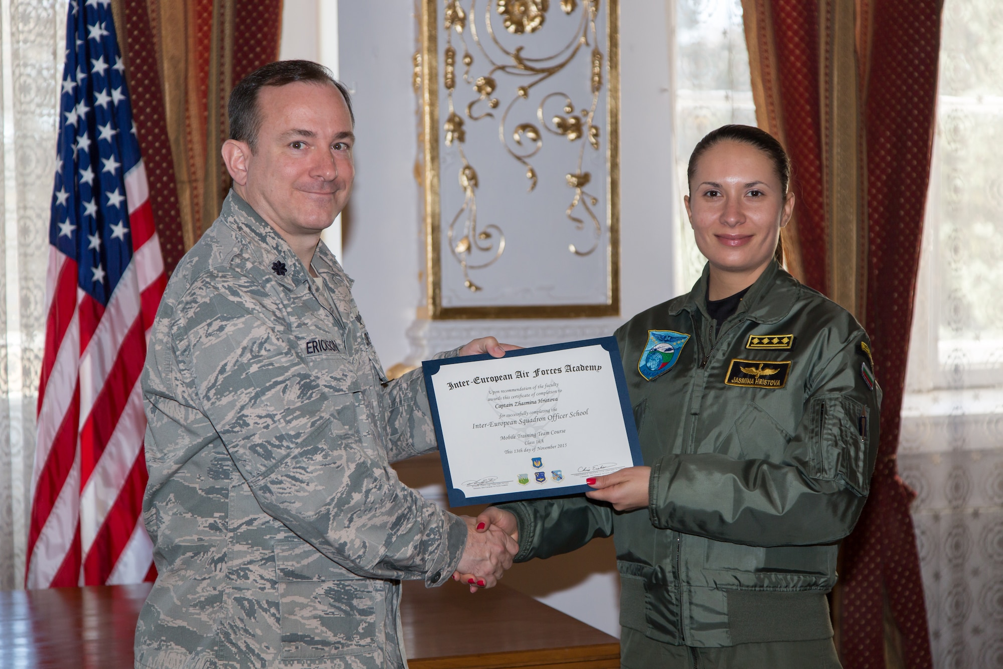 Lt. Col. Christopher Erickson, IEAFA Commandant, awards a certificate of completion to Captain Zhasmina Hristova, Bulgarian Air Force, during graduation of the first ever IEAFA combined international officer and NCO PME course graduation in Sofia, Bulgaria, Nov. 13, 2015. Twenty-three students from Bulgaria, Czech Republic, Estonia, and Hungary participated in this inagural course. (U.S. Air Force photo/SMSgt Travis Robbins/Released)