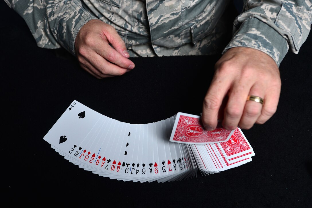 U.S. Air Force Master Sgt. Scott Fridinger, additional duty first sergeant assigned to the Air Combat Command Communications Support Squadron, performs a card wave at Langley Air Force Base, Va., Oct. 21, 2015. During his off-time, Fridinger teaches magic to children and performs shows. (U.S. Air Force photo by Senior Airman Aubrey White)