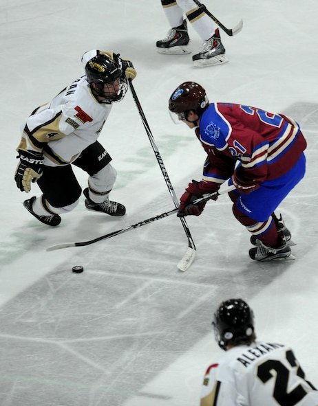 A member from the Minot Minotauros team handles a puck from a member from the Bismarck Bobcats during a game in Minot, N.D. Nov. 10, 2015. The game honored military veterans for Veteran’s Day. (U.S. Air Force photo by Staff Sgt. Chad Trujillo)