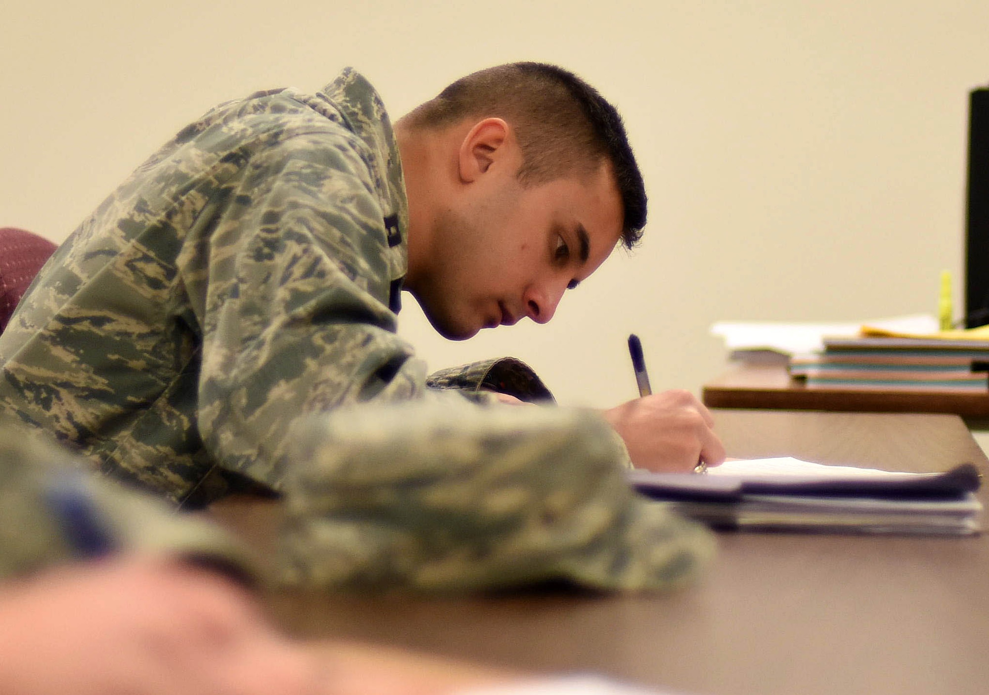 Capt. Christopher Lovas, 341st Operation Support Squadron combat crew commander, fills out required paperwork during a briefing at the Malmstrom Air Force Base, Mont. Traffic Management Office Nov. 16, 2015. Military members must coordinate with TMO personnel as part of their out processing checklist in order to facilitate a smooth transition from one duty station to another. (U.S. Air Force photo/Airman Collin Schmidt)
