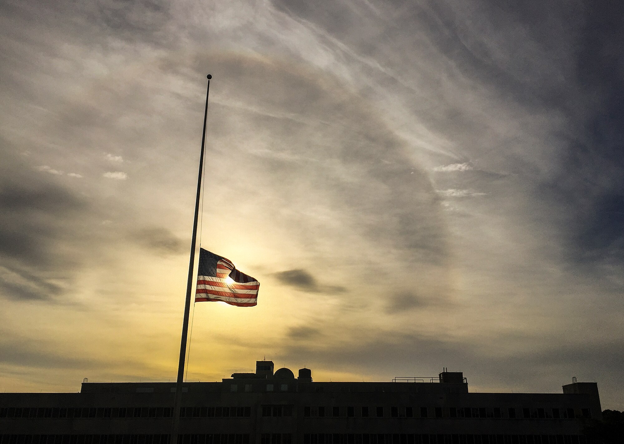 The sun rises over the lowered base headquarters American flag Nov. 17 at Eglin Air Force Base, Fla.  All government agency American flags were lowered to half-staff through Nov. 19 in solidarity to France after the recent terrorist attacks.  (U.S. Air Force photo/Samuel King Jr.)