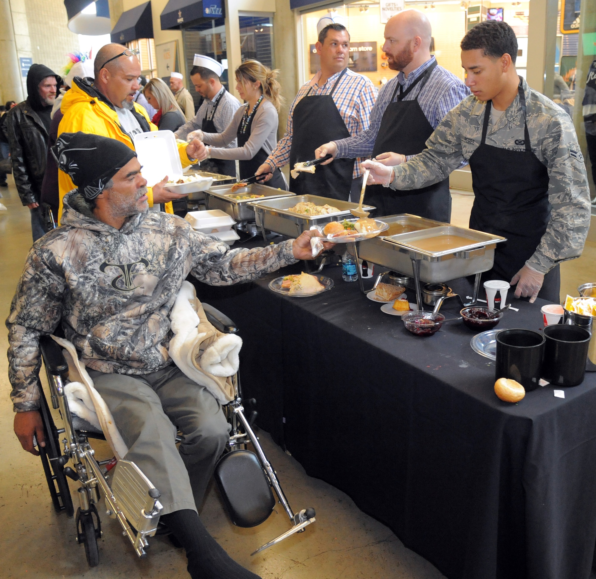 Airman 1st Class Darien Perez serves a hot Thanksgiving meal to Michael Howard Nov. 16 at Vivant Smart Home Arena in downtown Salt Lake City. Perez and other Airmen from Hill Air Force Base participated in the 17th annual community outreach event called We Care-We Share, which benefited thousands of Utah residents. (U.S. Air Force photo by Todd Cromar)