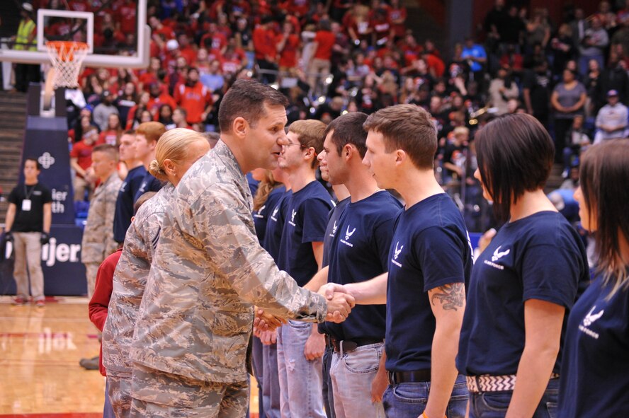 Col. John Devillier, 88th Air Base Wing commander, shakes the hand of Alexander Caylor following a swearing-in ceremony at the University of Dayton arena during Military Appreciation Night. (U.S. Air Force photo / Gina Marie Giardina)