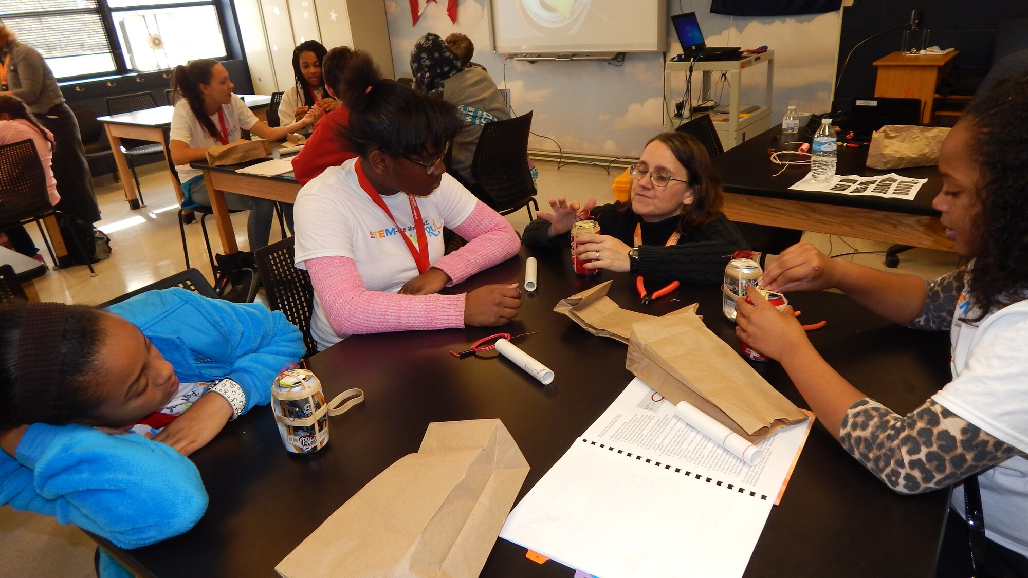 Dr. Rita Peterson, a volunteer at Wright-Patterson Air Force Base, helps (L-R) Ron'nea Judkins, Ashley Harris and Amirra Rankin during the 'STEM-ulate Your Mind: Girls RULE!' event on base Nov.7