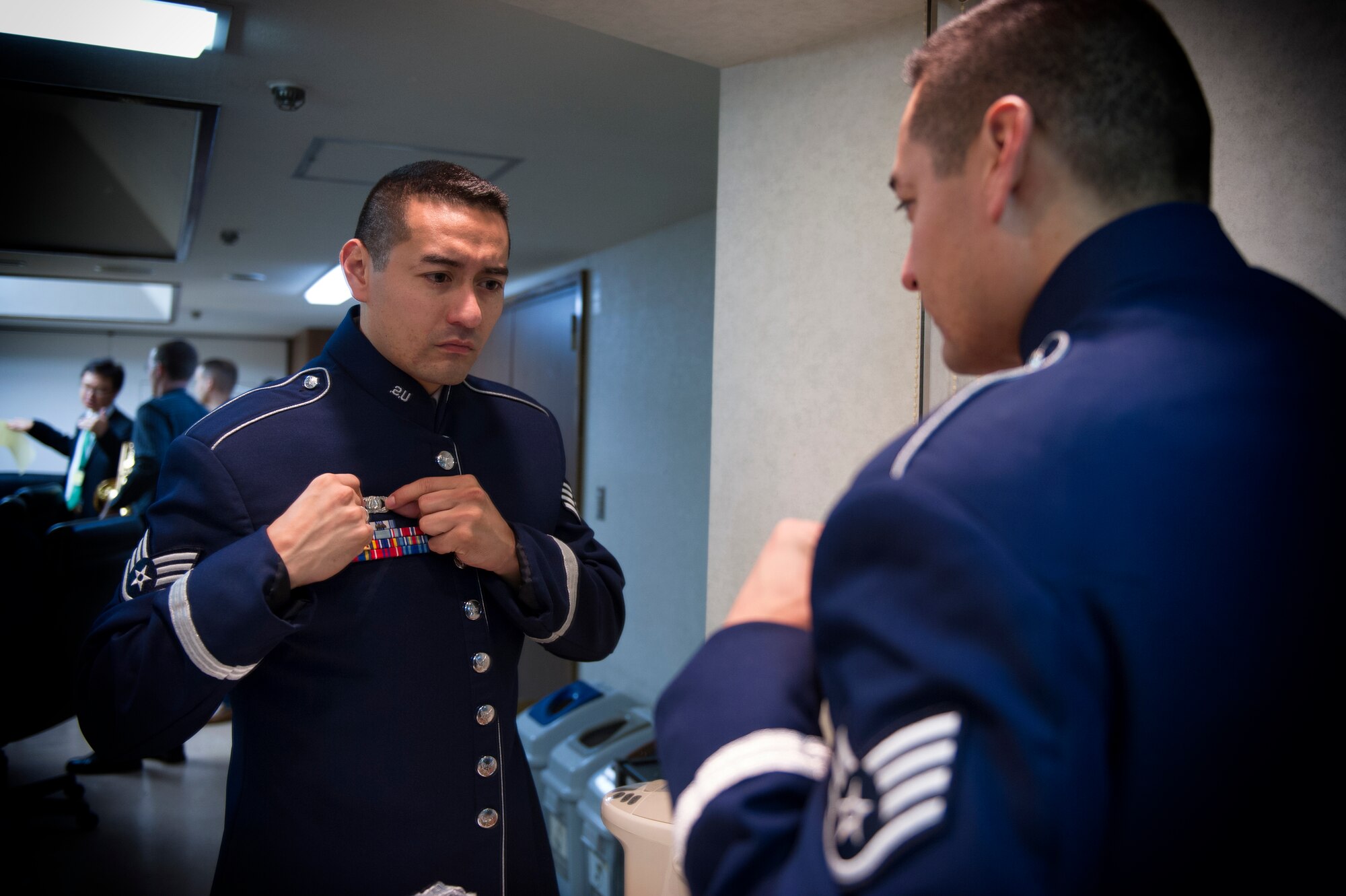 Staff Sgt. Dennis Lambert, U.S. Air Force Band of the Pacific pianist, inspects his service badge before leaving to perform at the Japan Self-Defense Force Marching Festival at the Nippon Budokan Arena in Tokyo, Japan, Nov. 13, 2015. By participating in the festival, the band was able to represent their country in front of the local population in the downtown Tokyo region. (U.S. Air Force photo by Airman 1st Class Delano Scott/Released)  