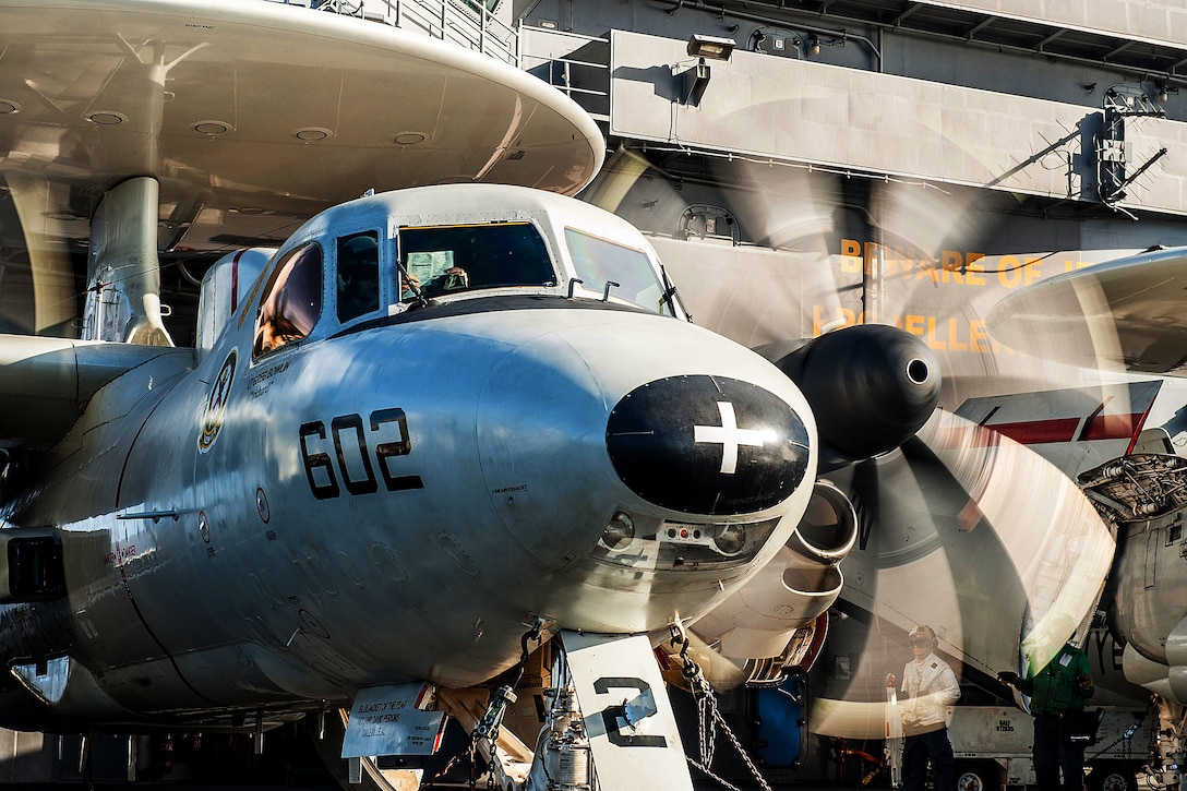 U.S. Navy Cmdr. David Waidelich performs a preflight check on an E-2C Hawkeye on the flight deck of the USS Ronald Reagan before a change of command ceremony in the Philippine Sea, Nov. 14, 2015. Waidelich assumed command of Carrier Airborne Early Warning Squadron 115 during the ceremony. U.S. Navy photo by Petty Officer 3rd Class Nathan Burke