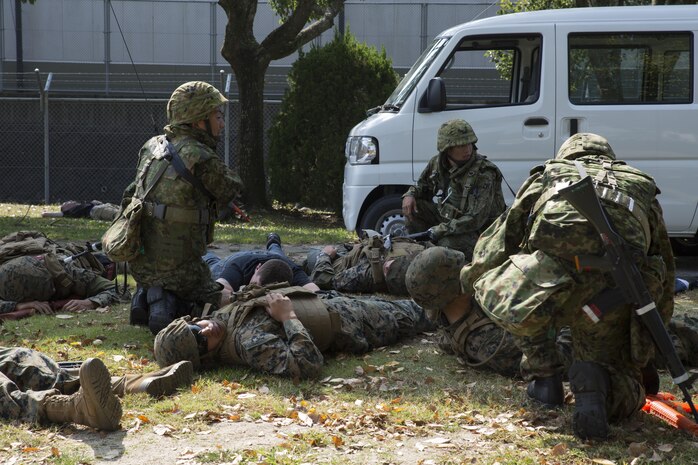 Marines and Japan Ground Self-Defense Force soldiers assess possible casualties in a simulated improvised explosive device explosion during Exercise Guard and Protect at Marine Corps Air Station Iwakuni, Japan, Oct. 20-23, 2015. Guard and Protect is a joint security force operation that enables readiness in case the station has to make a defense posture. The exercise tested the abilities of the Marines and Japanese soldiers to respond affectively in real world situations.