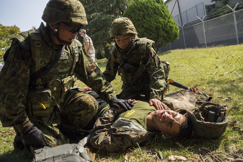 Japan Ground Self-Defense Force soldiers treat an injured Marine during a simulated improvised explosive device explosion during Exercise Guard and Protect at Marine Corps Air Station Iwakuni, Japan, Oct. 20-23, 2015. Exercise Guard and Protect is a joint security force operation that enables the station’s readiness in case the station has to make a defense posture. During the exercise Marines and JGSDF soldiers had to overcome the language barriers in order to affectively accomplish the mission.