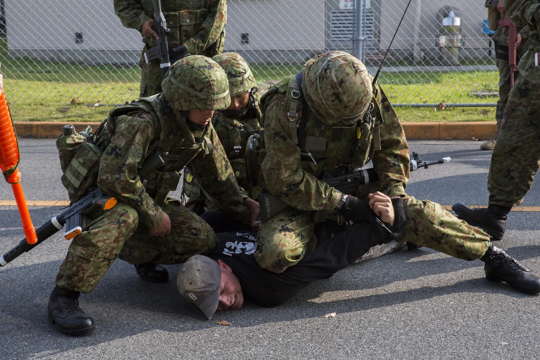 Japan Ground Self-Defense Force soldiers take down a kidnapper as part of a simulated situation during Exercise Guard and Protect at Marine Corps Air Station Iwakuni, Japan, Oct. 20-23, 2015. Guard and Protect is a joint security force operation to promote readiness in case the station has to make a defense posture. Marines and JGSDF soldiers carried out scenarios such as riot control, armed intruder response and vehicle searches.