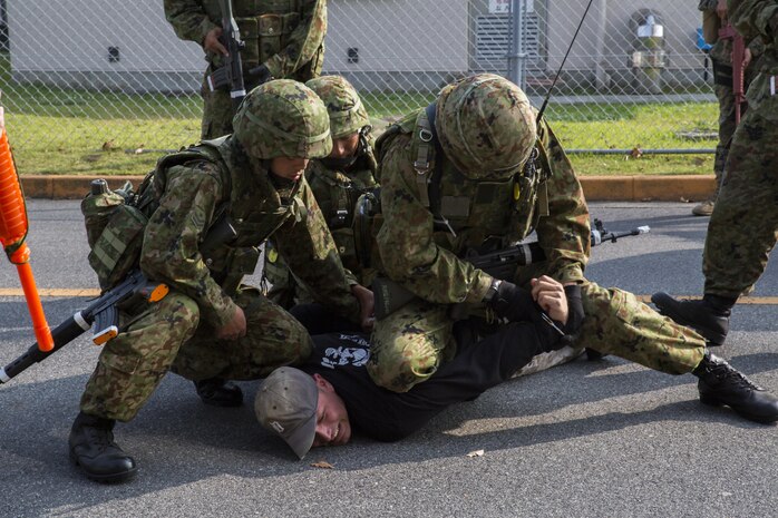 Japan Ground Self-Defense Force soldiers take down a kidnapper as part of a simulated situation during Exercise Guard and Protect at Marine Corps Air Station Iwakuni, Japan, Oct. 20-23, 2015. Guard and Protect is a joint security force operation to promote readiness in case the station has to make a defense posture. Marines and JGSDF soldiers carried out scenarios such as riot control, armed intruder response and vehicle searches.