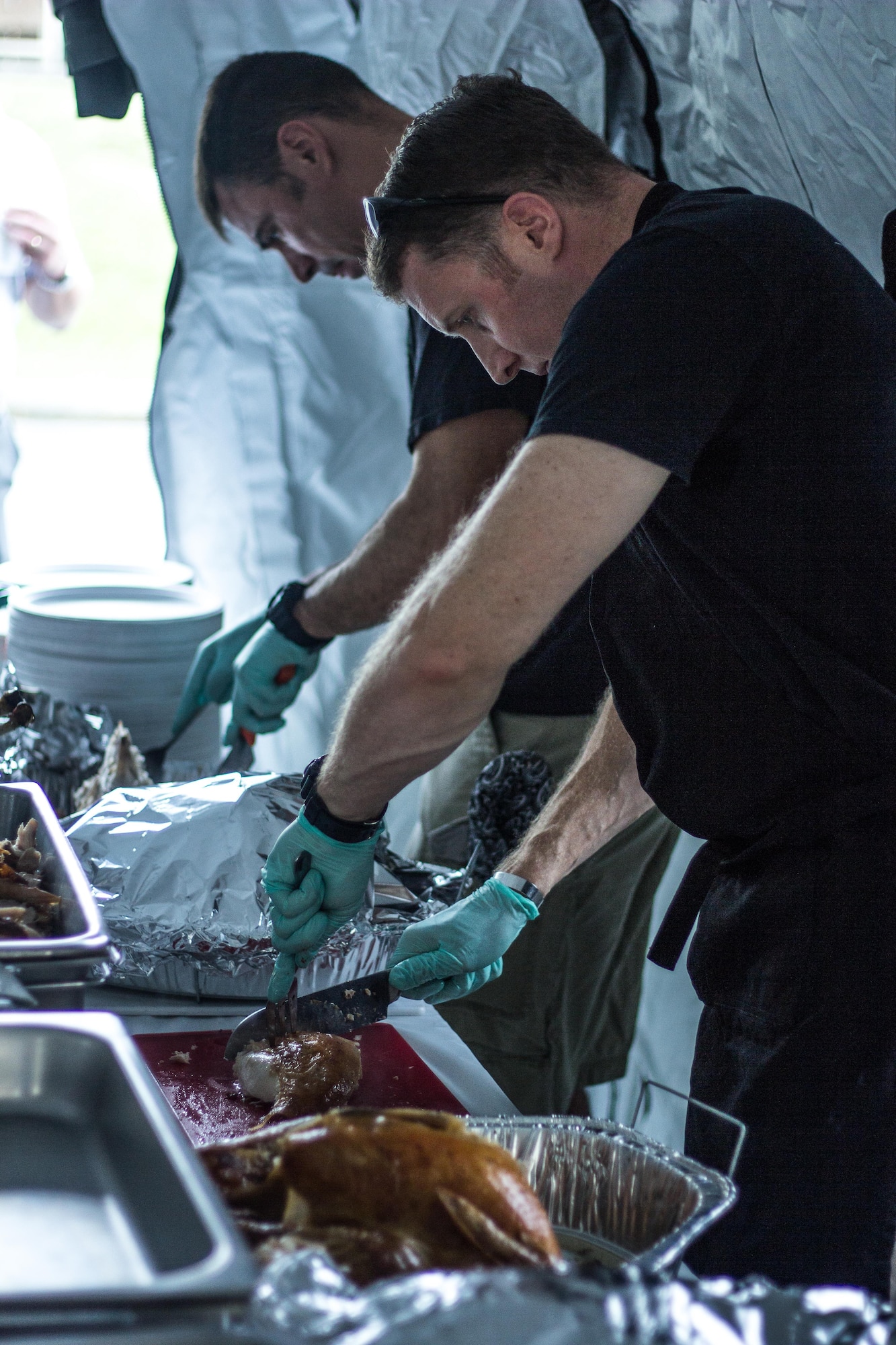 Lt. Col. Matthew Bartlett, 17th Special Operations Squadron, and Senior Master Sgt. Jeremy Tygrett, 353rd Special Operations Group, carves the turkeys during a Thanksgiving Dinner Nov. 14 on Kadena Air Base, Japan.  The 353rd Special Operations Group hosted the dinner for all SOG single Airmen and dorm residents.  More than 100 dishes were donated and nearly 100 Airmen to come together and enjoy the holiday dinner. (U.S. Air Force photo by Senior Airman Bobby Jackson) 