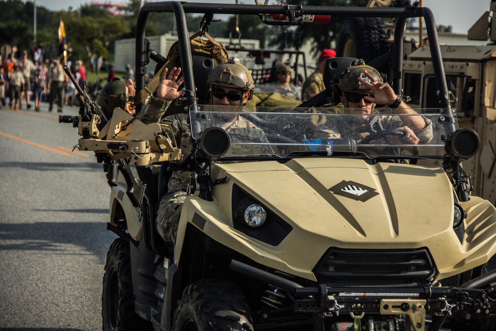 Two Airmen assigned to the 320th Special Tactics Squadron wave to the crowd during Kadena’s first Veterans Day parade held Nov. 11, 2015 at Kadena Air Base, Japan.  Service members from different branches of the United States military on Kadena Air Base, Japan, came together on Veterans Day to commemorate Veterans Day.  Veterans Day is held each year to honor the men and women, past and present, who have served in the military.  (U.S. Air Force photo by Senior Airman Bobby Jackson)