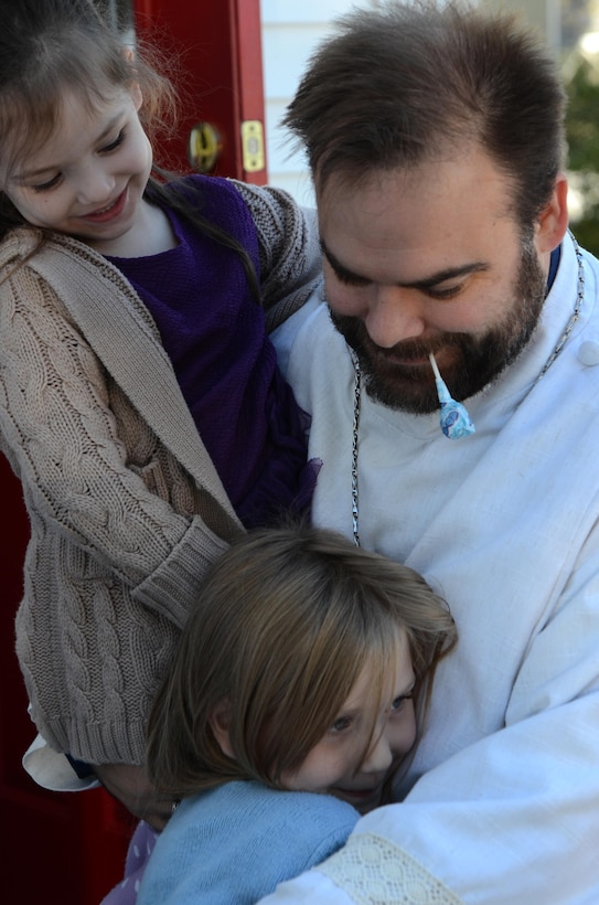 Riley Hignutt (left) and her sister Allison Hignutt (below) hug Pastor Stephen Woolverton after services Nov. 8, 2015, at Calvary United Methodist Church in Marydel, Md. Riley Hignutt was the first person Woolverton baptized after arriving at the church nearly three years ago.