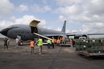 Soldiers of the Gladstone-based, 1430th Engineer Company, Michigan Army National Guard, Airmen and ground crew offload a Selfridge-based KC-135 from the Michigan Air National Guard on a tarmac in Liberia last week in preparation to assist with Liberia engineers as part of efforts to help the Liberians build new barracks buildings.  