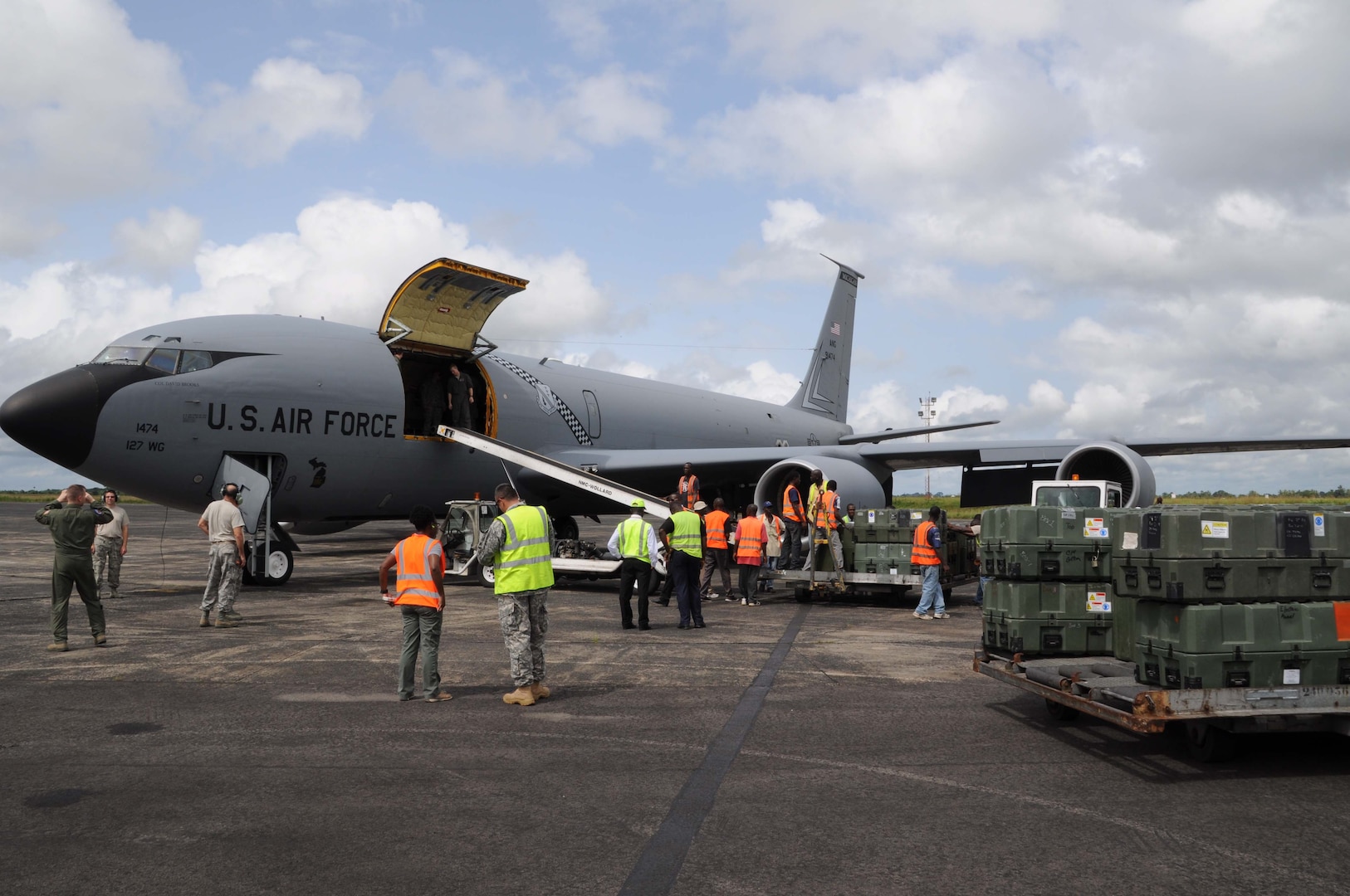 Soldiers of the Gladstone-based, 1430th Engineer Company, Michigan Army National Guard, Airmen and ground crew offload a Selfridge-based KC-135 from the Michigan Air National Guard on a tarmac in Liberia last week in preparation to assist with Liberia engineers as part of efforts to help the Liberians build new barracks buildings.  