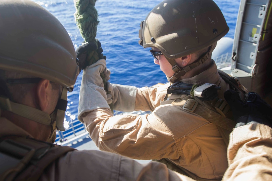 A U.S. Marine prepares to fast-rope out of an SH-60 Seahawk helicopter aboard the amphibious assault ship USS Kearsarge in the North Red Sea, Nov. 5, 2015. U.S. Marine Corps photo by Cpl. Jalen D. Phillips