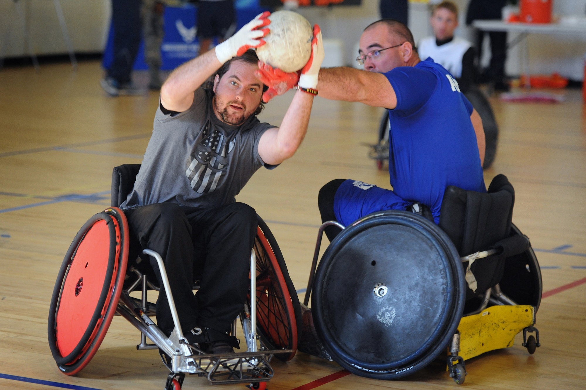 A player representing U.S. Special Operations Command hustles for possession against an Air Force player during tournament play Nov. 16, 2015, at Joint Base Andrews, Md. Wounded warriors from all branches of the armed forces participated in the Warrior CARE Month’s Joint Services Wheelchair Rugby Exhibition. (Defense Department photo/Marvin Lynchard)