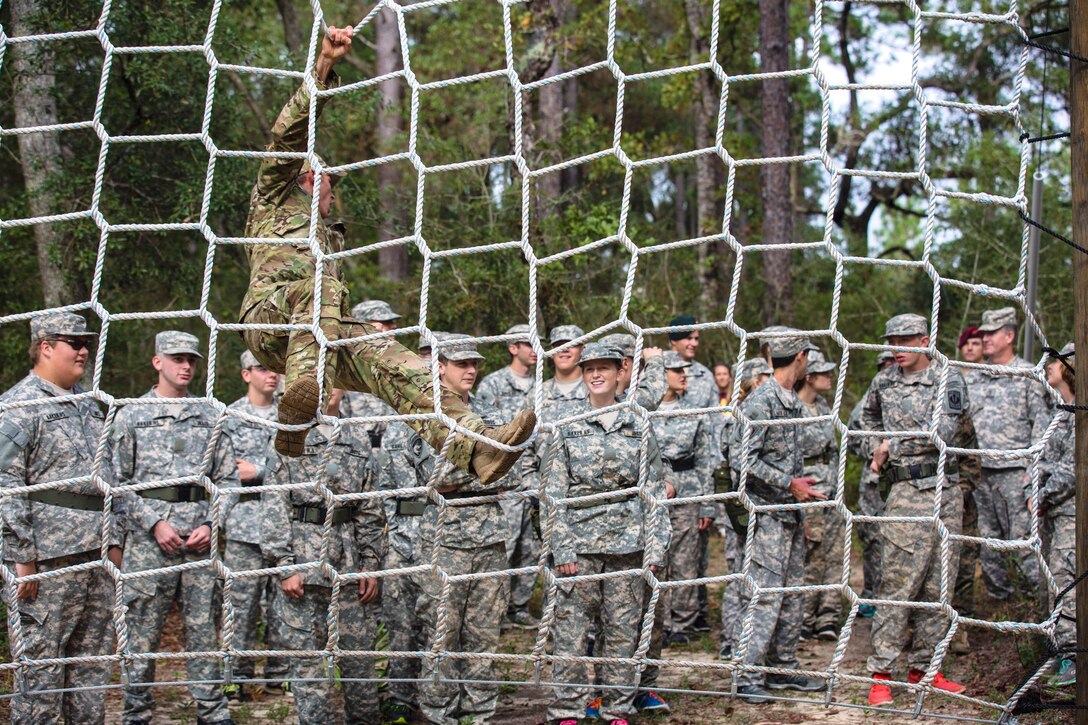 An Army Green Beret demonstrates how to safely climb a cargo net obstacle to Army Junior Officer Reserve Training Corps cadets on Eglin Air Force Base, Fla., Nov. 10, 2015. U.S. Army photo by Pfc. David Stewart