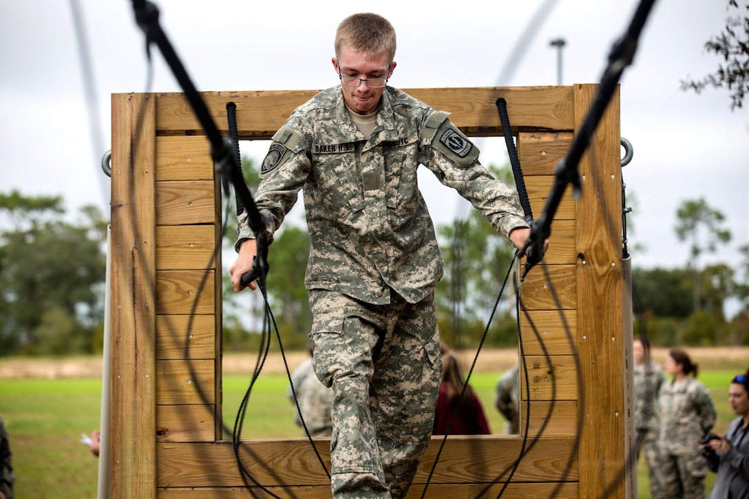 An Army Junior Officer Training Corps cadet navigates a three-rope bridge on Eglin Air Force Base, Fla., Nov. 10, 2015. U.S. Army photo by Pfc. David Stewart