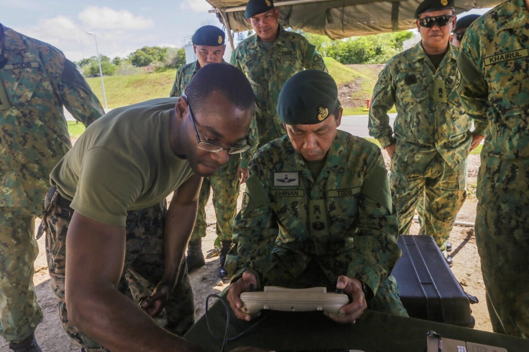 TUTONG, Brunei  (Nov. 11, 2015) U.S. Marine Cpl. Mark Weatherspoon, left, shows Royal  Brunei Land Force Brig. Gen. Pengiran Dato Seri Pahlawan Aminan Bin Pengiran Haji Mahmud the controls for a Raven small unmanned aerial vehicle during Combined Afloat Readiness and Training - Brunei 2015. Weatherspoon is a rifleman with Battalion Landing Team 3rd Battalion, 1st Marine Regiment, 15th Marine Expeditionary Unit.  Brig. Gen. Aminan is the Chief of the Army for the Royal Brunei Land Forces. Elements of the 15th MEU Marines are ashore in Brunei to perform day and night training in an urban environment and to enhance interoperability and partnership between the U.S. and Brunei. The 15th MEU is currently deployed in the Indo-Asia-Pacific region to promote regional stability and security in the U.S. 7th Fleet area of operations. (U.S. Marine Corps photo by Sgt. Jamean Berry/Released)