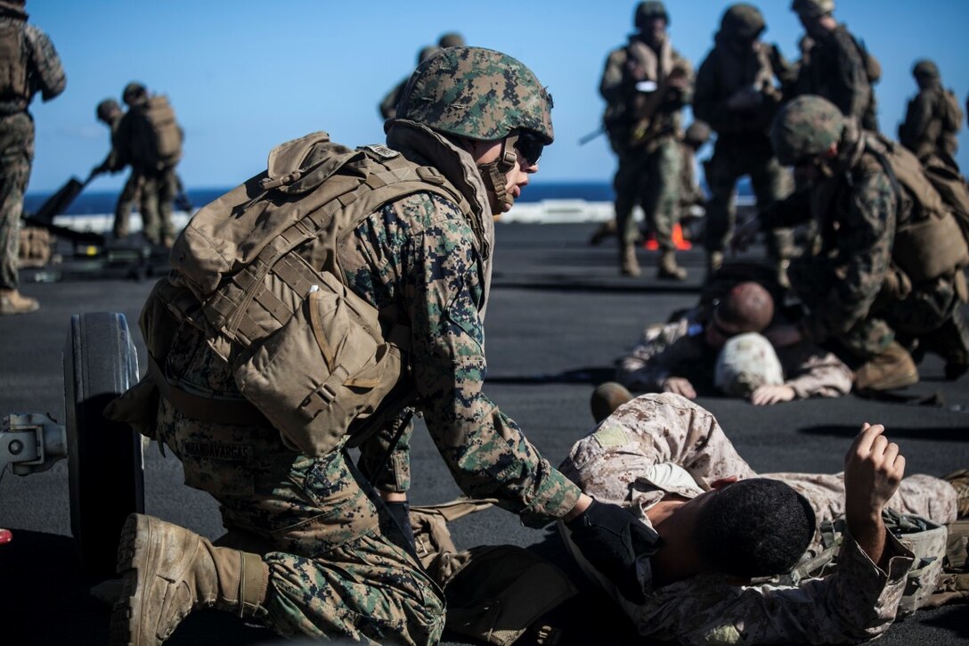 SOUTH CHINA SEA (Nov. 16, 2015) U.S. Sailors and Marines with Combat Logistics Battalion 15, 15th Marine Expeditionary Unit, tend to simulated causalities during a mass-casualty drill on the flight deck of the USS Essex (LHD 2). The Marines and Sailors honed their skills to become quicker and more efficient should a situation arise where medical attention is needed. The 15th MEU is currently deployed in the Indo-Asia-Pacific region to promote regional stability and security in the U.S. 7th Fleet area of operations. (U.S. Marine Corps photo by Cpl. Elize McKelvey/Released)