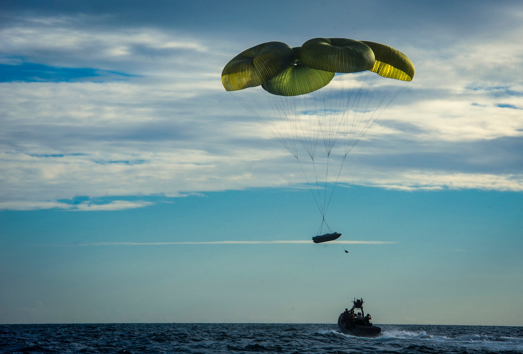 A rigid inflatable boat descends into the Gulf of Mexico after being deployed from an MC-130H Combat Talon II during Maritime Craft Aerial Delivery Systems (MCADS) training, Nov. 12, 2015. MCADS enable special operation forces members to rapidly deploy anywhere around the world in a maritime environment. (U.S. Air Force photo by Senior Airman Meagan Schutter)