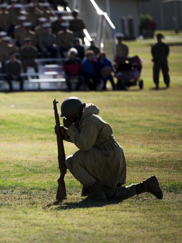 Cpl. Antwan James, barracks manager, Headquarters Battalion, dressed in Korean War attire, pauses for a moment to pray for service members who gave their lives in combat during the annual Marine Corps Birthday Uniform Pageant at Lance Cpl. Torrey L. Gray Field, Nov. 10, 2015. (Official Marine Corps photo by Lance Cpl. Levi Schultz/Released)