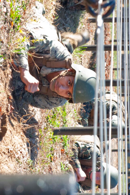 Staff Sgt. Miguel Gamboa, The Basic School, low crawls through an obstacle course during the final event to complete the Marine Corps Martial Arts instructor trainer course at The Basic School. Training during the seven-week course is based on three synergies: physical, mental and character.