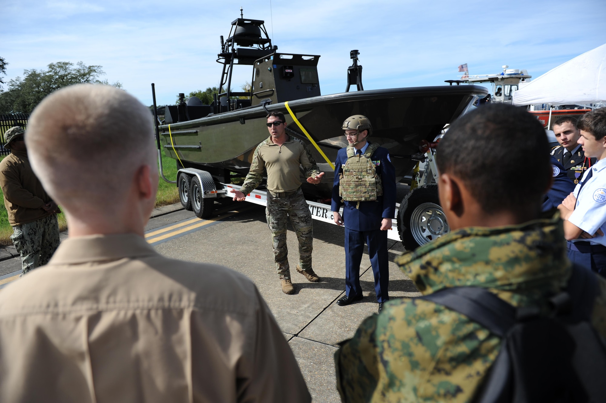 Navy Special Boat Operator 1st Class James Penick, Naval Small Craft Instructional and Technical Training School, Stennis Space Center, Miss., discusses the use of body armor worn by Cadet Ryan Watts, Lafayette High School Air Force Junior ROTC, Oxford, Miss., during the second annual Mississippi All-Services Junior ROTC Drill Competition Nov. 14, 2015, at Keesler Air Force Base, Miss. Recruiting booths and static displays, including military vehicles, equipment and an aircraft were available to the cadets throughout the competition. (U.S. Air Force photo by Kemberly Groue)