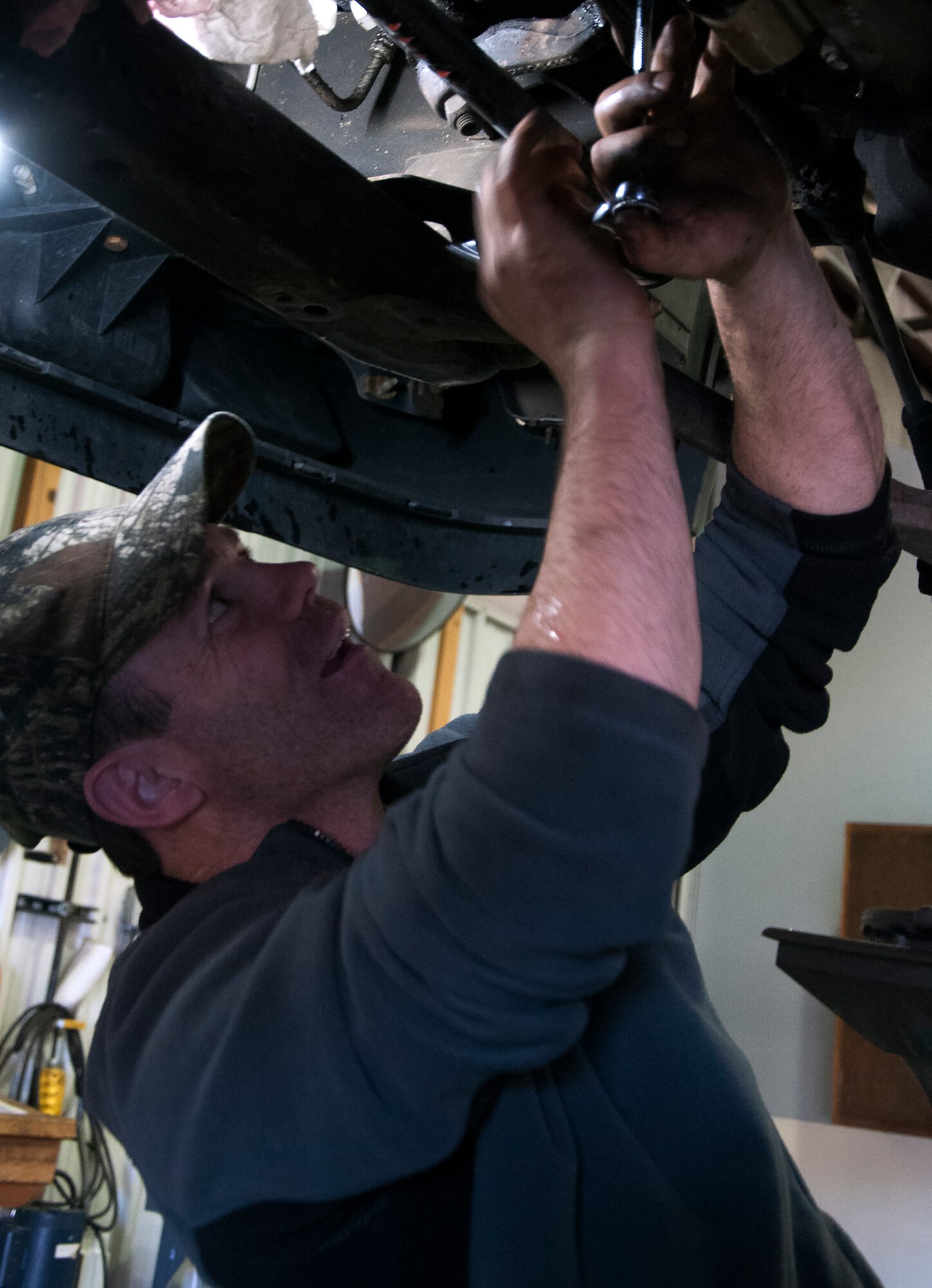 Retired Tech. Sgt. Timothy Staples removes a bolt from the underside of a truck Nov. 13, 2015, in the Auto Skills Shop on F.E. Warren Air Force Base, Wyo. With access to lifts and tools, Airmen and retirees can work on vehicles without needing to go to a mechanic. (U.S. Air Force photo by Senior Airman Brandon Valle)