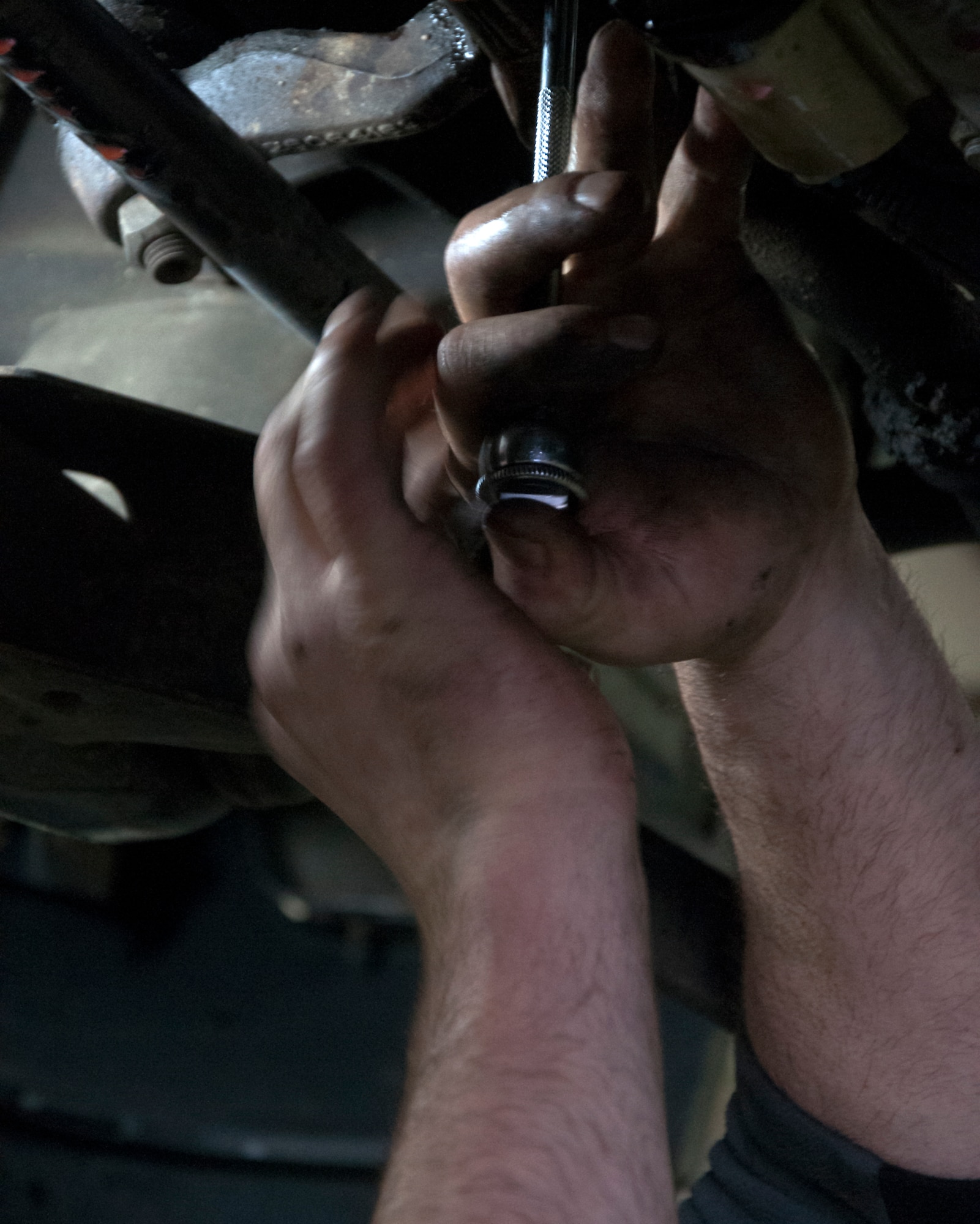 Retired Tech. Sgt. Timothy Staples removes a bolt from the underside of a truck Nov. 13, 2015, in the Auto Skills Shop on F.E. Warren Air Force Base, Wyo. The Auto Skills Shop provides tools and resources that many don’t have access to at home. (U.S. Air Force photo by Senior Airman Brandon Valle)