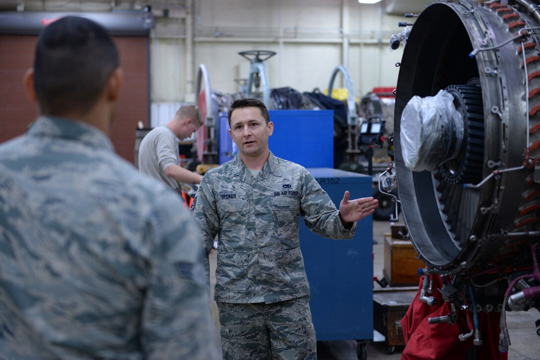 Staff Sgt. Joseph Decker, 56th Component Maintenance Squadron aerospace propulsion journeyman, educates the Airmen of the Immersion program group on jet engine facts and maintenance processes at Luke, Nov. 13, 2015. For some of the Airmen in the group, the Immersion program gave them their first experience in any part of the processes and procedures involved in maintaining aircraft. (U.S. Air Force photo by Airman 1st Class Ridge Shan)