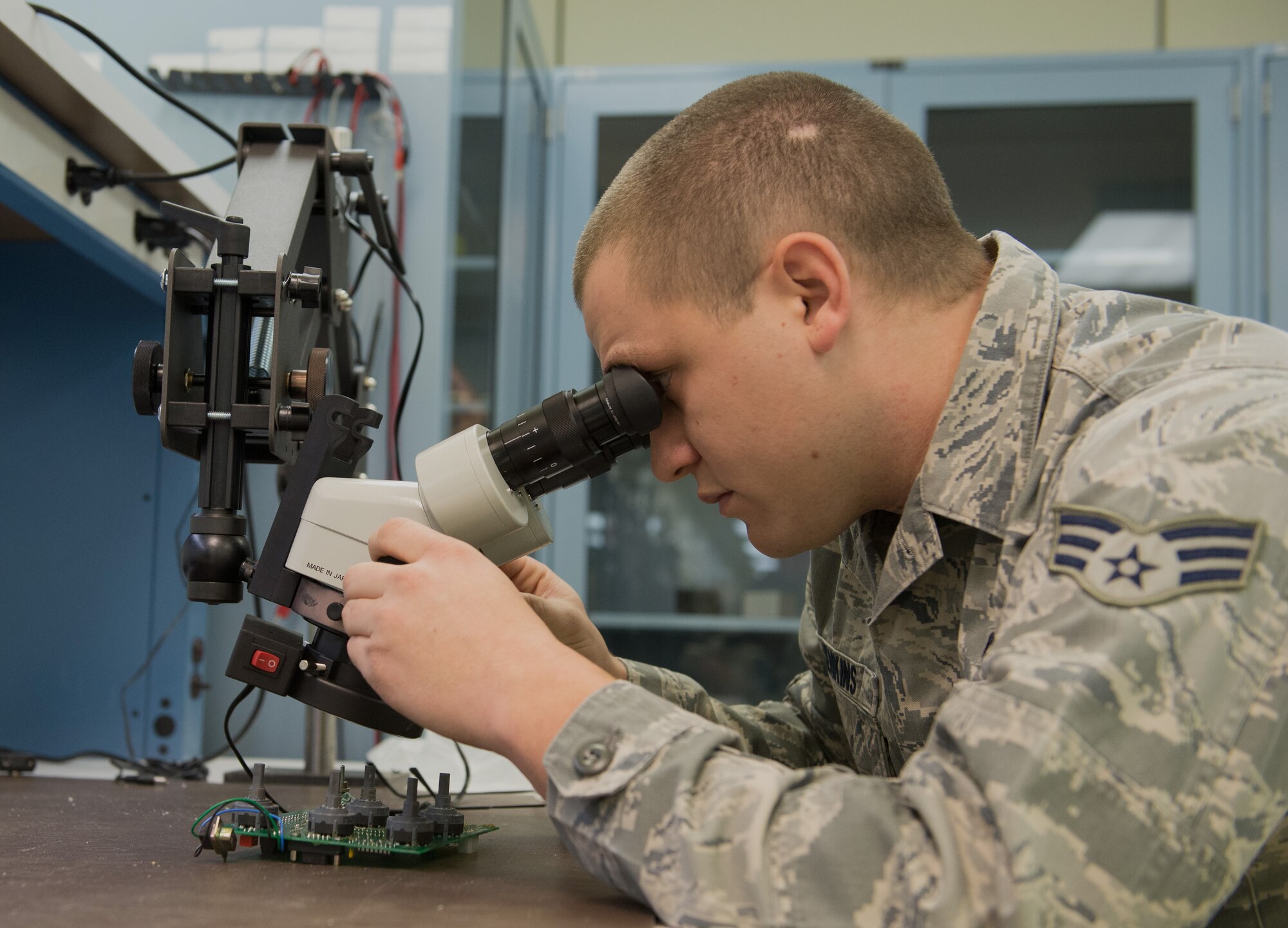 U.S. Air Force Senior Airman Tyler Jenkins, an Air Force Repair Enhancement Program technician with the 354th Maintenance Squadron, looks through a microscope Nov. 16, 2015, at Eielson Air Force Base, Alaska. Jenkins inspected a speed panel used by the 354th Security Forces Squadron to ensure the soldering joints are serviceable. (U.S. Air Force photo by Airman 1st Class Cassandra Whitman/Released)