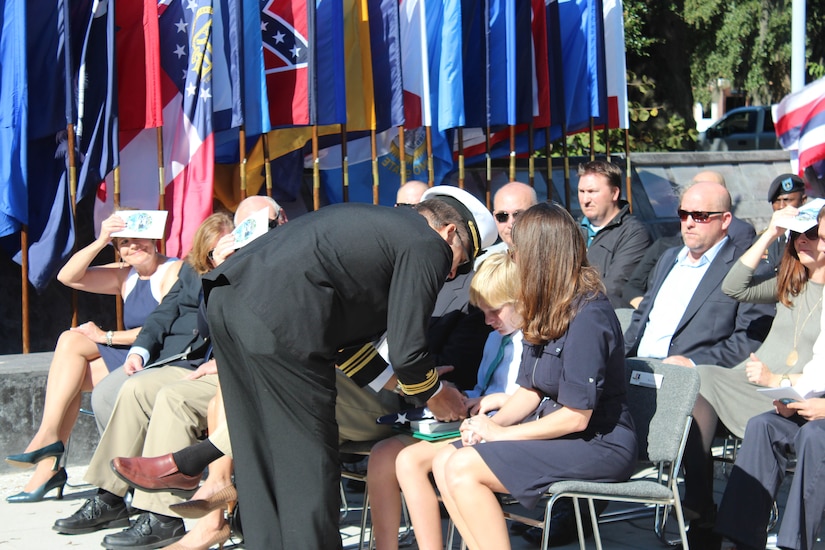 Lieutenant Commander Seifert presents the U.S. flag to his son during his retirement ceremony on Oct. 30, 2015 at the Navy Memorial Amphitheater in North Charleston, S.C. Seifert’s 23 year career  included assignments as Food Service Officer, Logistics, Plans and Policy Officer, Force Ordnance Officer, JTF-HOA Operations Logistics Officer, Instructor/Clearance Officer, Naval Postgraduate School.