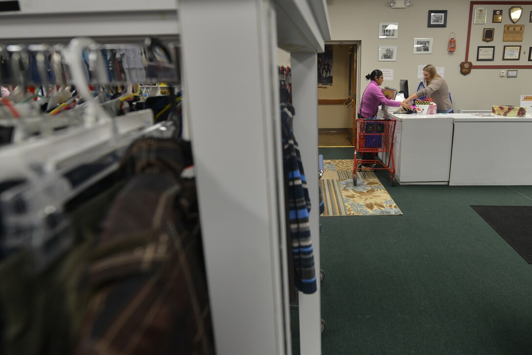Kasey Gore, a cashier with the Whistle Stop thrift store, assists Susana Hernandez with her purchases at Fort Eustis, Va., Nov. 17, 2015. The Whistle Stop is operated by the Spouses’ Club of Fort Eustis, and its proceeds go toward creating and supporting community events and programs. (U.S. Air Force photo by Staff Sgt. Natasha Stannard)