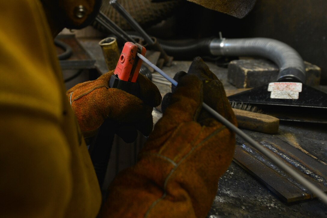 U.S. Army Pfc. Edward Allen, a railway operation student with the Maritime and Intermodal Training school, attaches a new welding rod to a machine during a class at Fort Eustis, Va., Oct. 23, 2015. The welding shop teaches watercraft engineer and railway operation students concepts and techniques on various types of metals. (U.S. Air Force photo by Staff Sgt. Natasha Stannard)