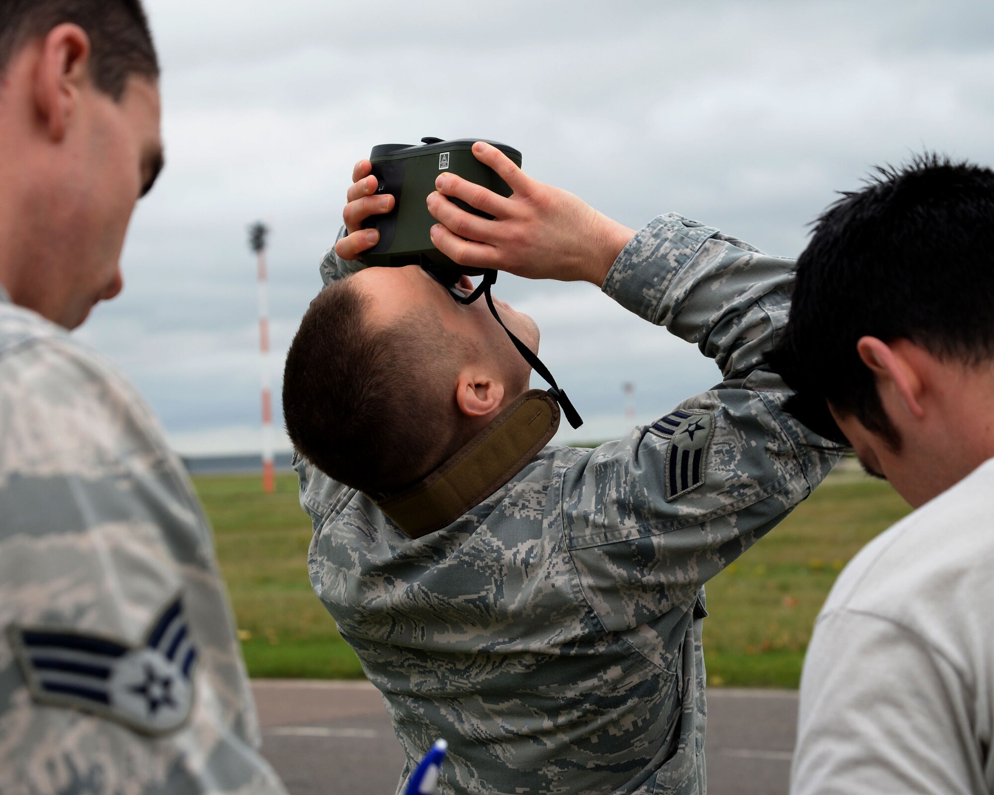 U.S. Air Force Senior Airman Brian Huck, center, 352nd Special Operations Group weather forecaster, uses a laser rangefinder to determine the height of base clouds Nov. 10, 2015 on RAF Mildenhall, England. The laser rangefinder can also be used to judge distances of certain landmarks around the airfield to judge visibility. The binocular-like equipment is used during manual observations because it can be utilized by a single observer and without the assistance of fixed equipment. (U.S. Air Force photo by Airman 1st Class Justine Rho/Released) 