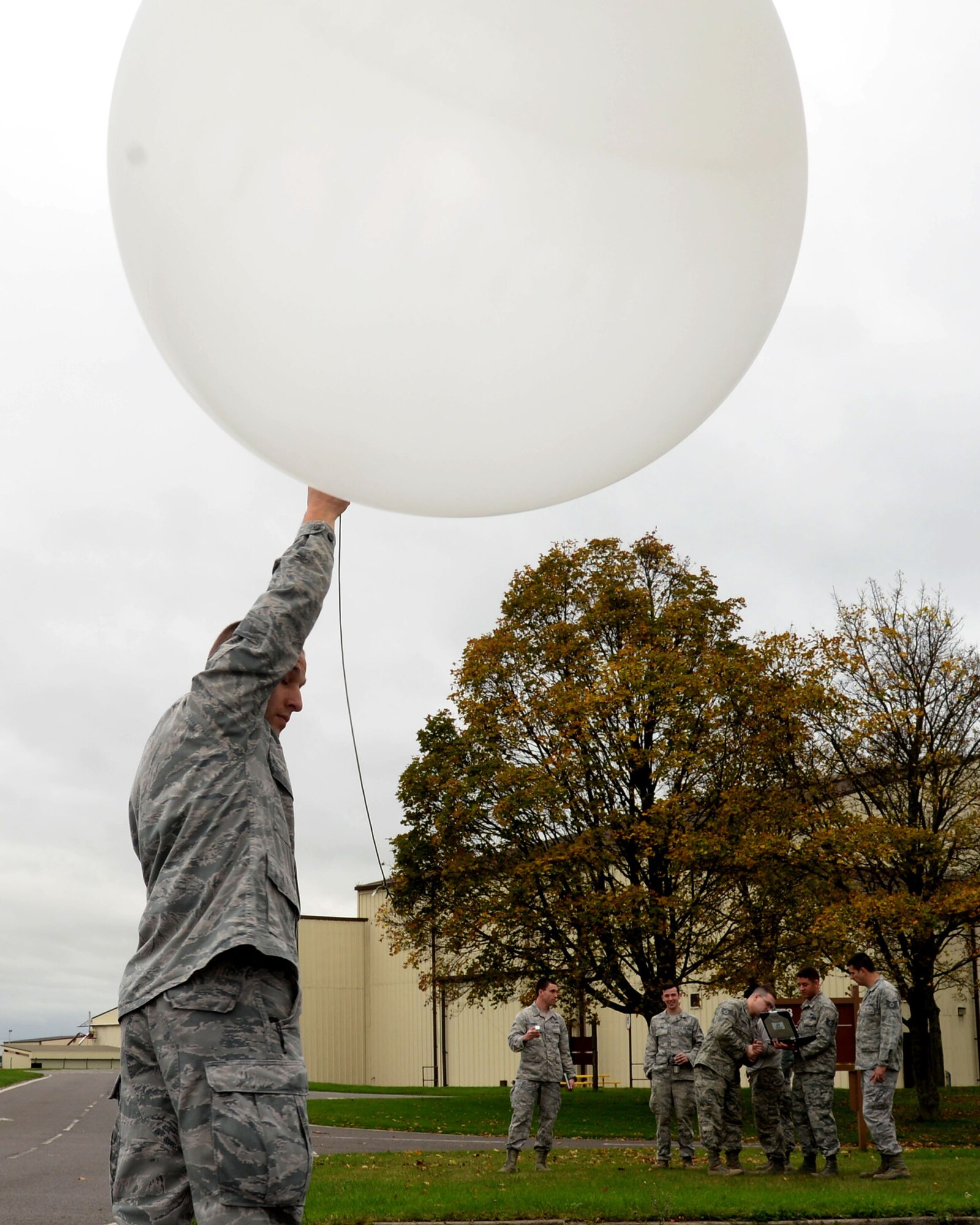 U.S. Air Force Senior Airman Brian Huck, left, 352nd Special Operations Group weather forecaster, prepares to launch a weather balloon Nov. 10, 2015, at RAF Mildenhall, England. The weather balloon carries a radiosonde, weather sensing equipment, through the atmosphere and collects statistics, such as wind data, temperature, dew point and pressure. The weather balloon system can take accurate readings at great heights, even at 40 to 90 thousand feet. (U.S. Air Force photo by Airman 1st Class Justine Rho/Released) 