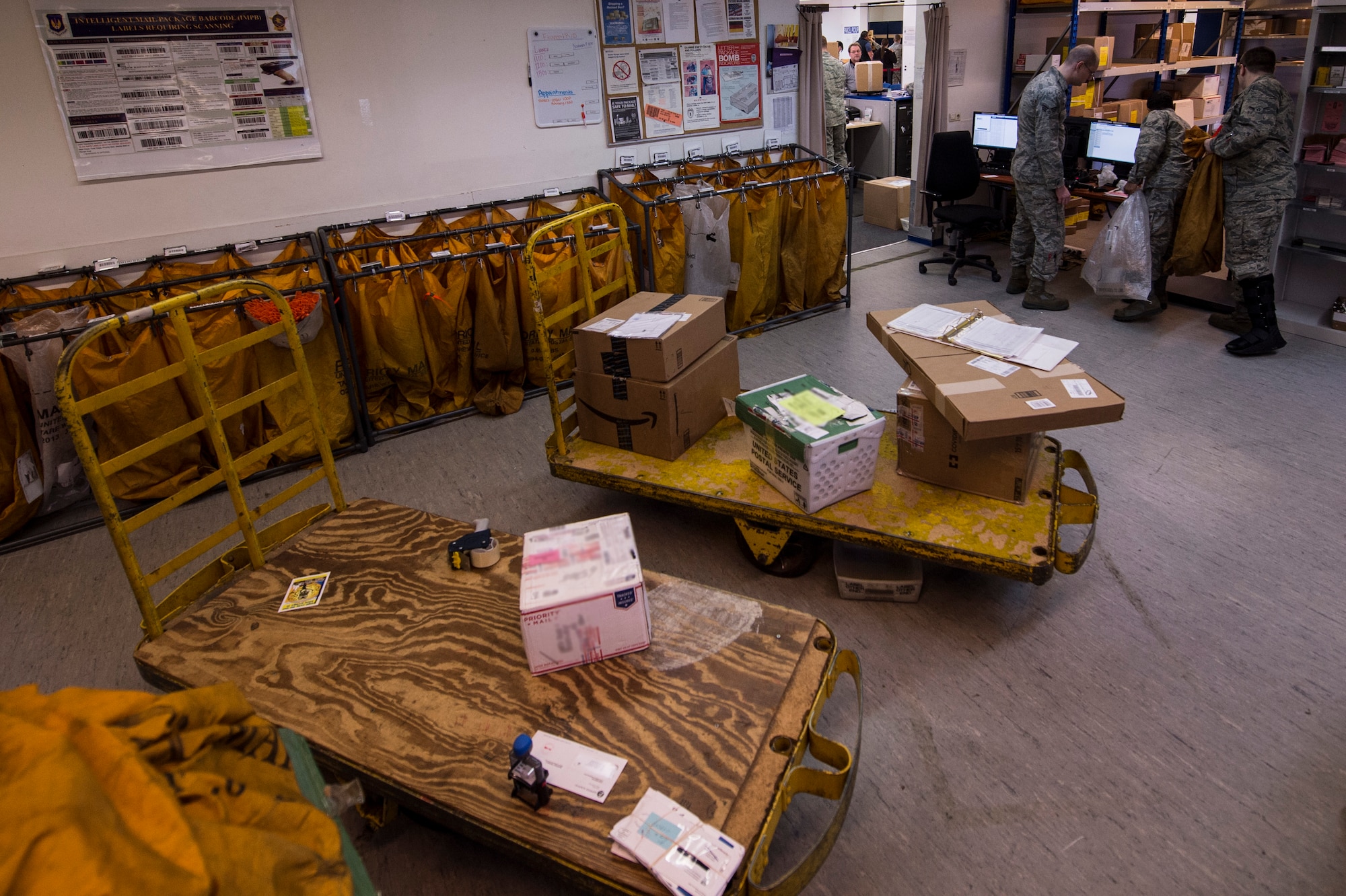 Airmen work inside the post office at Spangdahlem Air Base, Germany, Nov. 9, 2015. The Airmen who work at the post office serve all base personnel and help, on average, 940 customers a week. (U.S. Air Force photo illustration by Senior Airman Rusty Frank/Released)