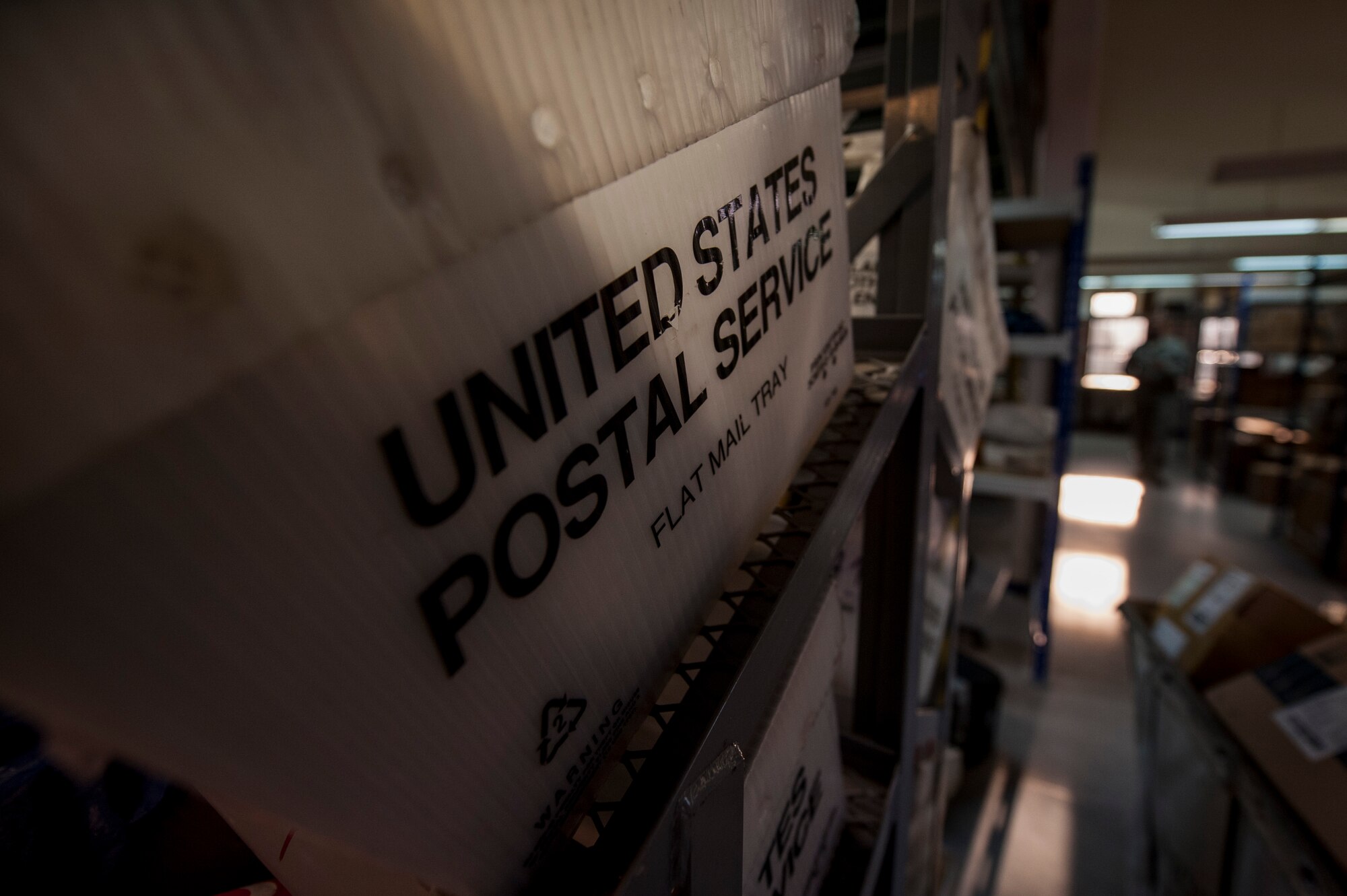 A U.S. Postal Service bin sits on a shelf inside the post office at Spangdahlem Air Base, Germany, Nov. 17, 2015. The Airmen who work at the post office process all mail within a 24-hour period excluding magazines which they must process in a 72-hour period. They also help, on average, 940 customers a week. (U.S. Air Force photo by Senior Airman Rusty Frank/Released)