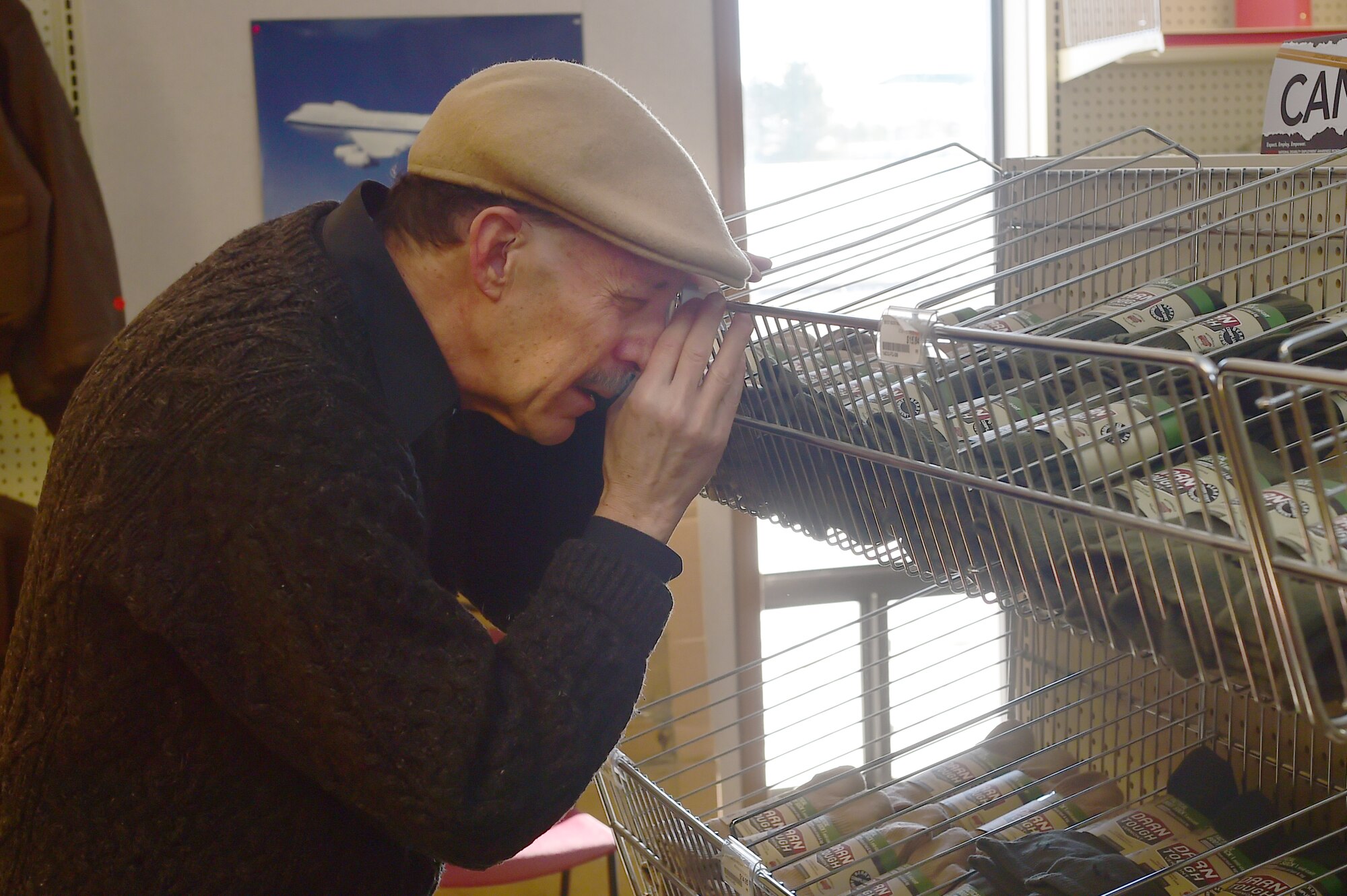 Robert A. Weinberg, Envision Express employee, uses a magnifying glass to identify an item Nov. 18, 2015, on Buckley Air Force Base, Colo. Weinberg worked as an accomplished photographer before losing part of his eyesight in the mid 1990’s. (U.S. Air Force photo by Airman 1st Class Luke W. Nowakowski/Released)