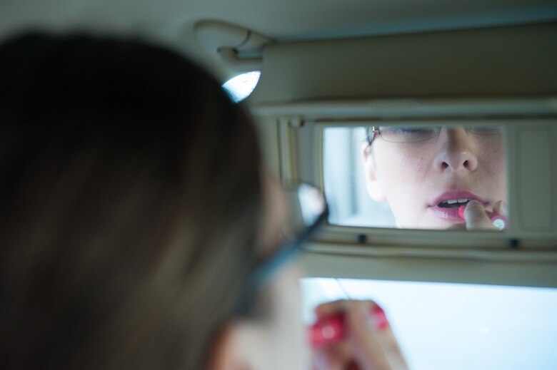 Senior Airman Kyla Gifford, 30th Space Wing photojournalist, applies lipstick while driving her car Oct. 29, 2015, Vandenberg Air Force Base, Calif. According to statistics from the National Highway Traffic Safety Administration, nine people are killed every day, and more than 1,153 people are injured in crashes that involve a distracted driver. (U.S. Air Force photo by Michael Peterson/Released)