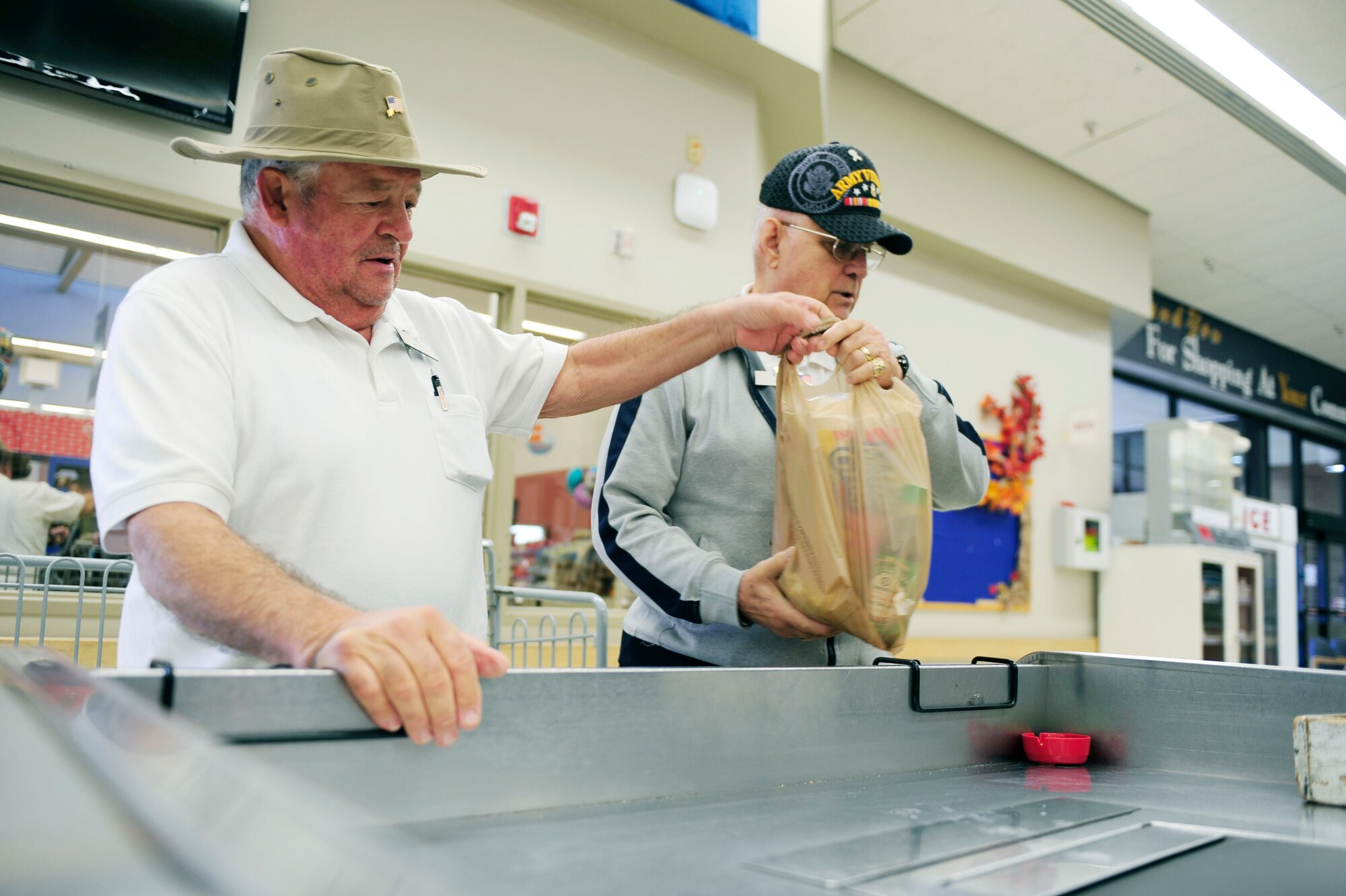 Retired Army Staff Sgt. Robert Michaud and retired Sgt. 1st Class Richard Estes, Vandenberg Commissary baggers, bag groceries, Nov. 18, 2015, Vandenberg Air Force Base, Calif. Michaud and Estes are military veterans who continue to serve in the commissary. (U.S. Air Force photo by Staff Sgt. Jim Araos) 