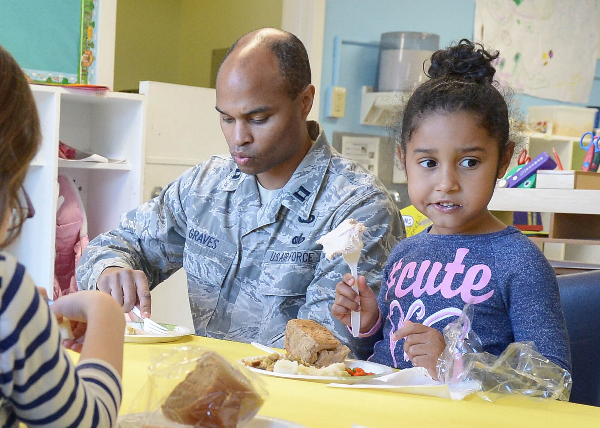 Captain Michael Graves, Battle Management Directorate contracting officer, eats a Thanksgiving-style meal with his daughter, Jazlynn, at the School Age Program Nov. 18 as part of a Month of the Military Family activity. This was established to recognize the sacrifices and contributions made by every member of the military family. Originally established in 1993, Military Family Month was first celebrated by the Armed Services YMCA, according to the organization's website. The U.S. government has recognized the occasion every year since. (U.S. Air Force photo by Jerry Saslav)

