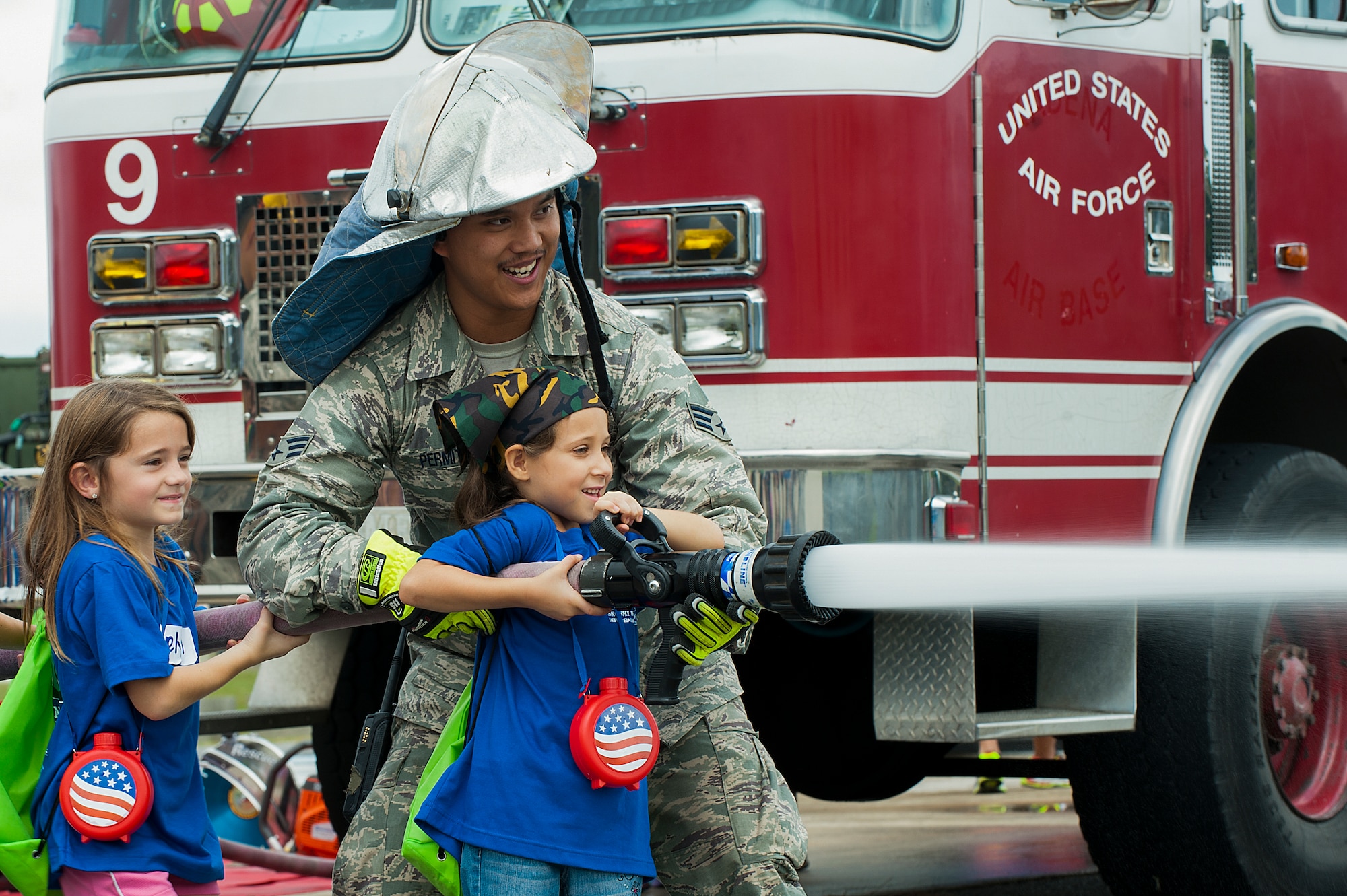 U.S. Air Force Staff Sgt. Darren Harris, 18th Security Forces Squadron, shows children how the radio on the patrol car works at Skoshi Warrior Nov. 14, 2015, at Kadena Air Base, Japan. More than 200 children participated in this annual event, meant to show children their parents’ deployment process and to see different aspects of military jobs. (U.S. Air Force photo by Airman 1st Class Corey M. Pettis)   
