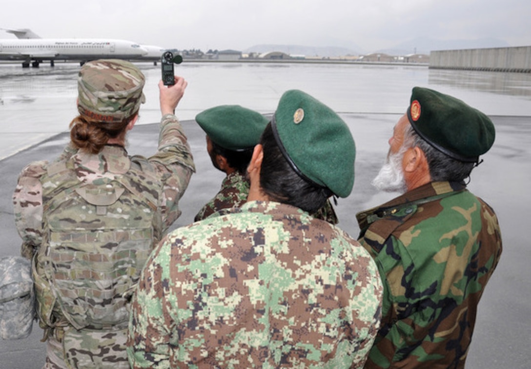 Capt. Haley Homan, Train, Advise, Assist Command – Air (TAAC-Air) weather advisor, demonstrates how to use a Kestrel – an instrument to measure temperature, moisture, wind speed and pressure. The Afghan Air Force (AAF) weather forecasters participated in the practical exercise and reported weather observations such as visibility, sky condition and wind direction, which the Kestrel cannot sense. Th